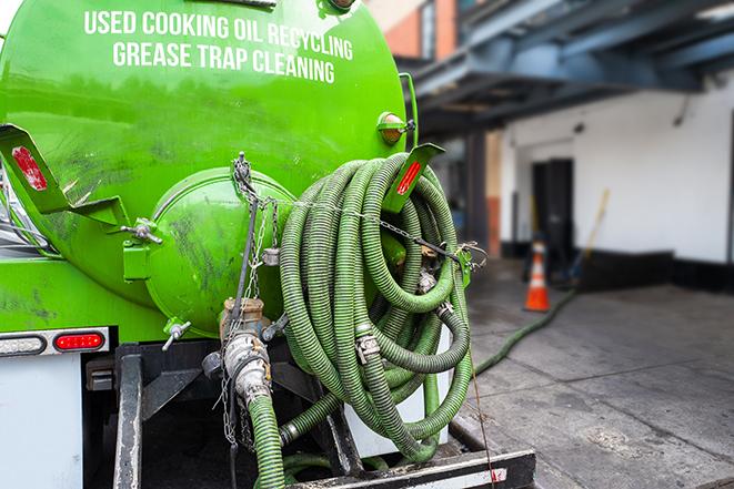 a grease trap being pumped by a sanitation technician in Deerfield IL